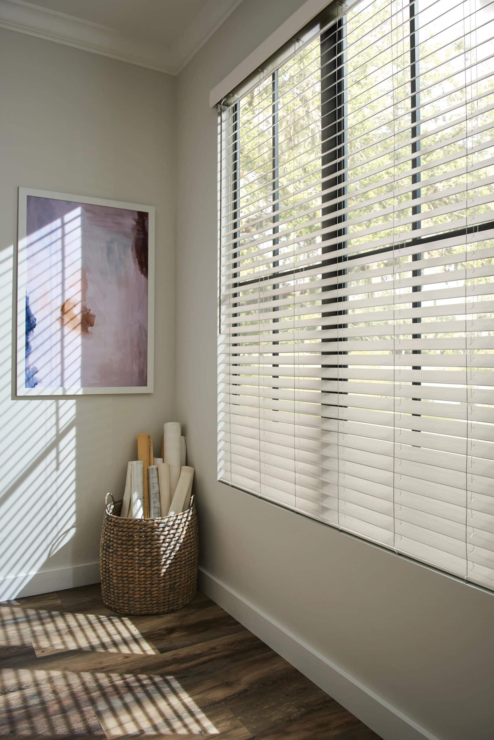 Faux-wood blinds filtering in light in a beautiful living room.